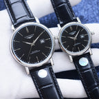 Longines watch pair with black dials, silver cases, black leather straps, date windows