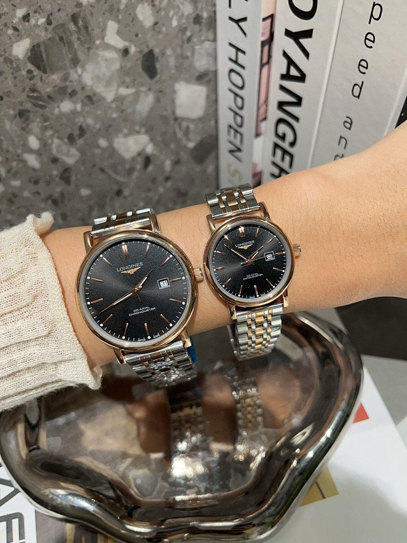 Two Longines watches with black dials, rose-and-silver cases, stainless link bracelets.