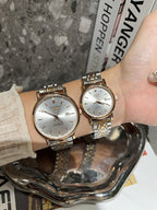 Two Longines watches with white dials and rose-gold and gold-tone link bracelets.