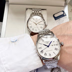 Longines watch with white dial, Roman numerals, and steel bracelet on wrist