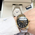 Longines watch with dark dial, gold bezel, and metal bracelet on wrist
