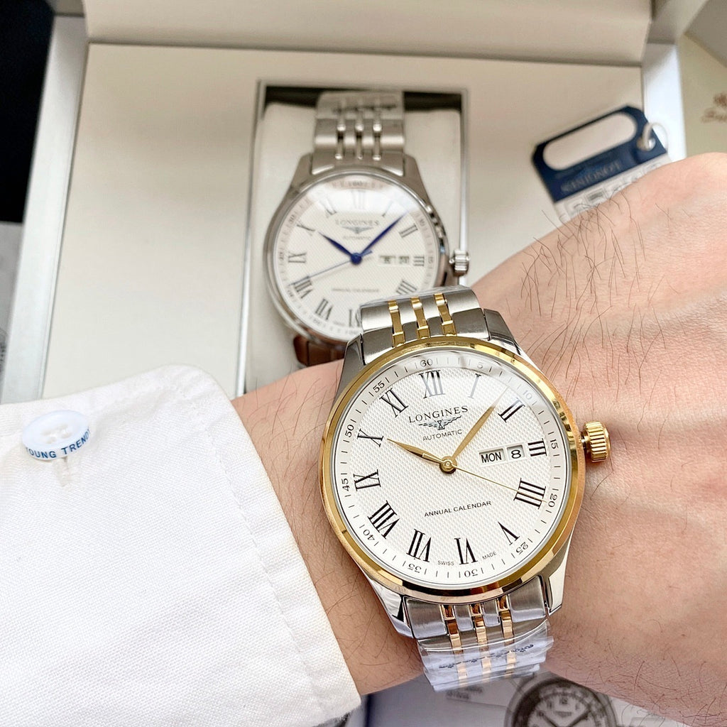 Longines watch with white dial, gold bezel, and two-tone metal bracelet on wrist
