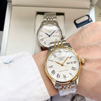 Longines watch with white dial, gold bezel, and two-tone metal bracelet on wrist