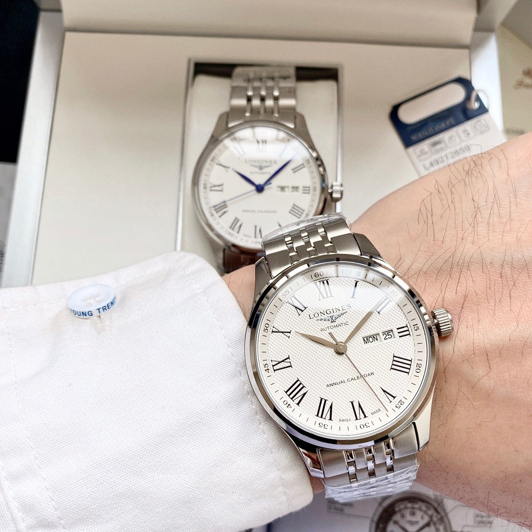 Longines watch with white dial and steel bracelet on wrist, date MON 25