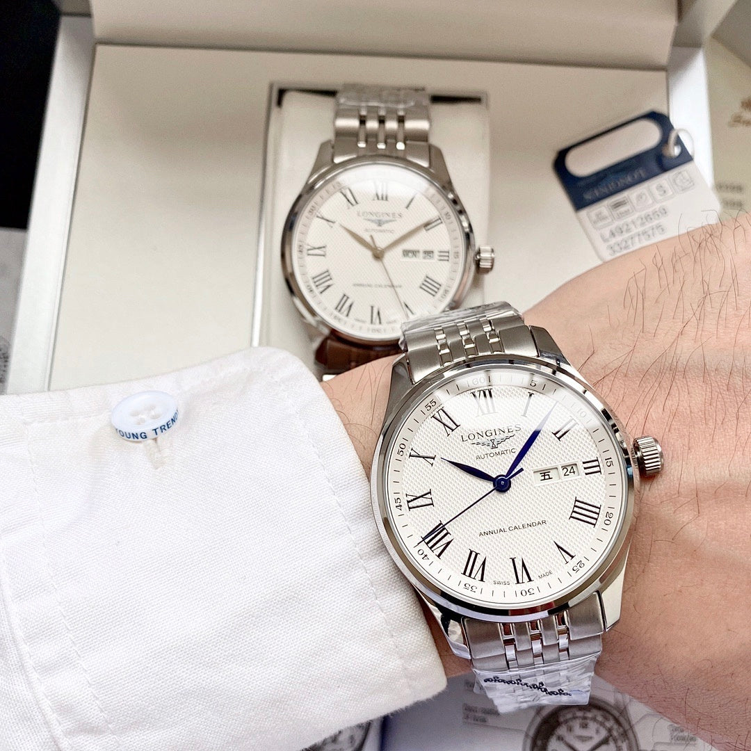 Longines watch with white dial, blue hands, and steel bracelet on wrist