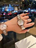 Longines rose gold-tone wristwatch on wrist, round white dial and metal bracelet