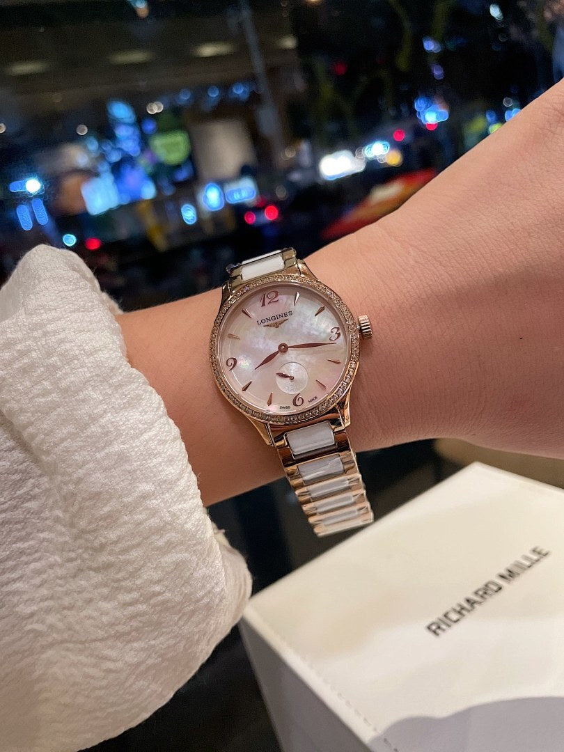 Longines rose gold-tone wristwatch with pale dial and metal link bracelet