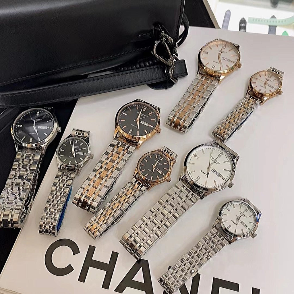 Assorted metal wrist watches with dark and white dials laid out in a set