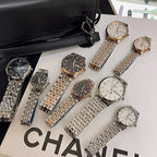 Assorted metal wrist watches with dark and white dials laid out in a set