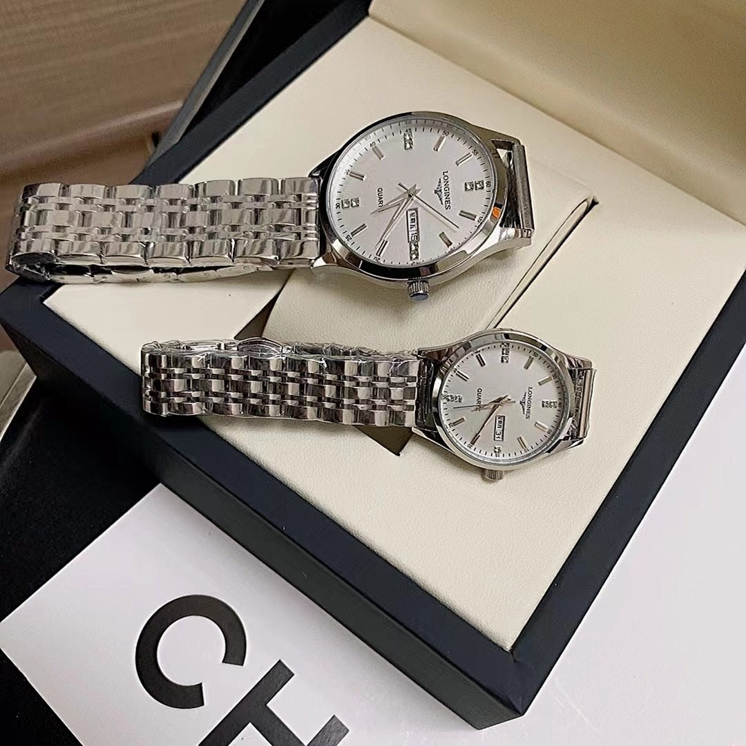 Stainless steel wrist watches with white dials and link bracelets on a gift tray