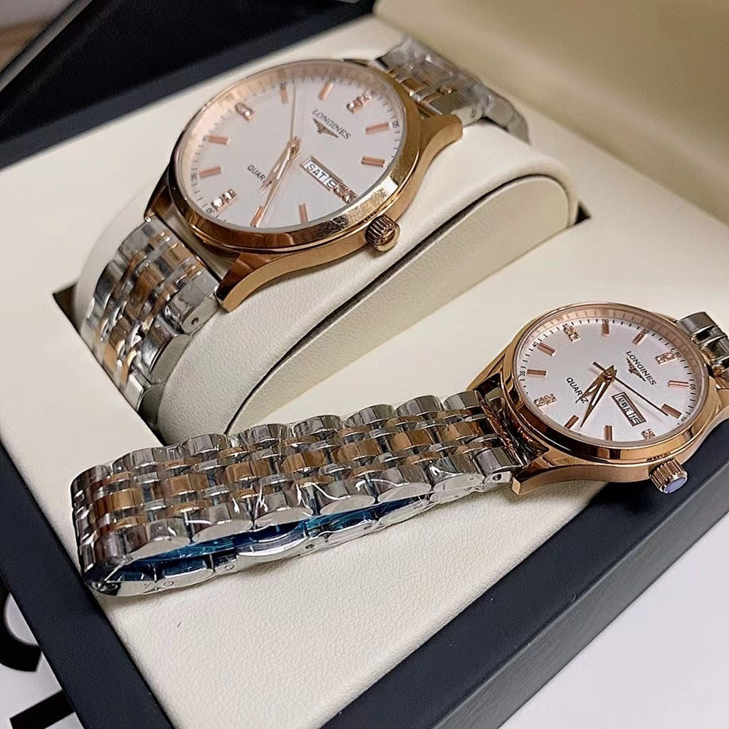 Gold-tone and stainless steel wrist watches with white dials on a box insert