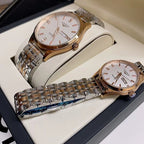 Gold-tone and stainless steel wrist watches with white dials on a box insert