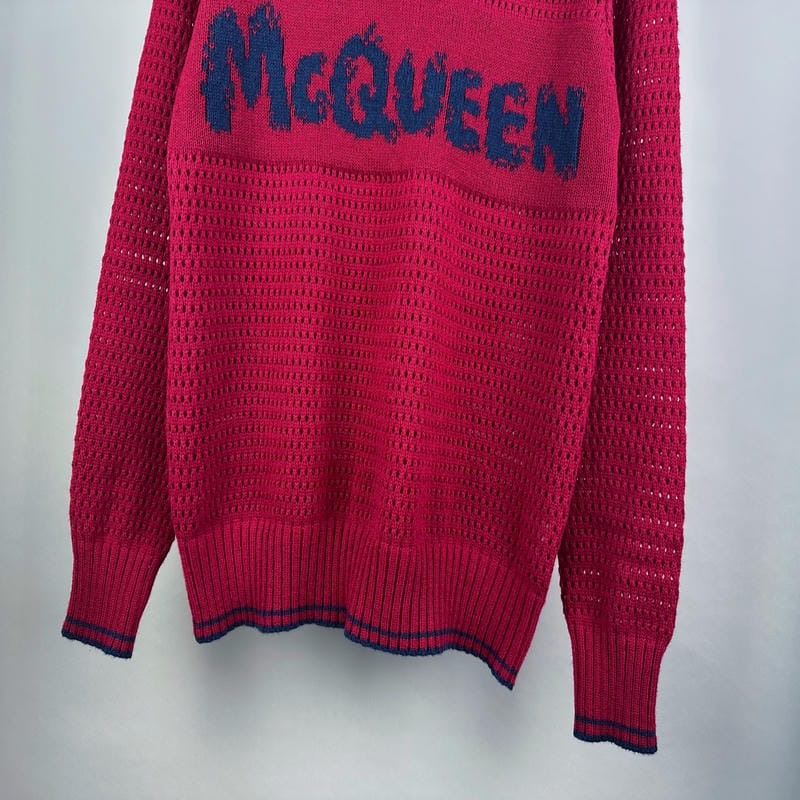 Magenta knit sweater lower front with ribbed cuffs and blue striped hem