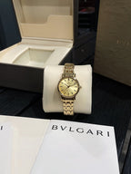 Omega wristwatch with gold-tone bracelet and champagne dial on display cushion