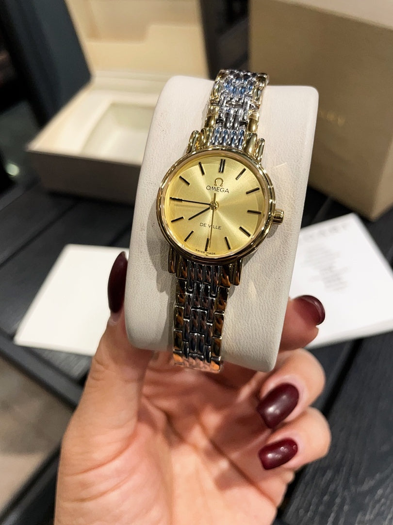 Omega wristwatch with gold-tone case, gold dial, and linked metal bracelet
