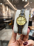 Omega wristwatch with gold dial and linked metal bracelet in front view