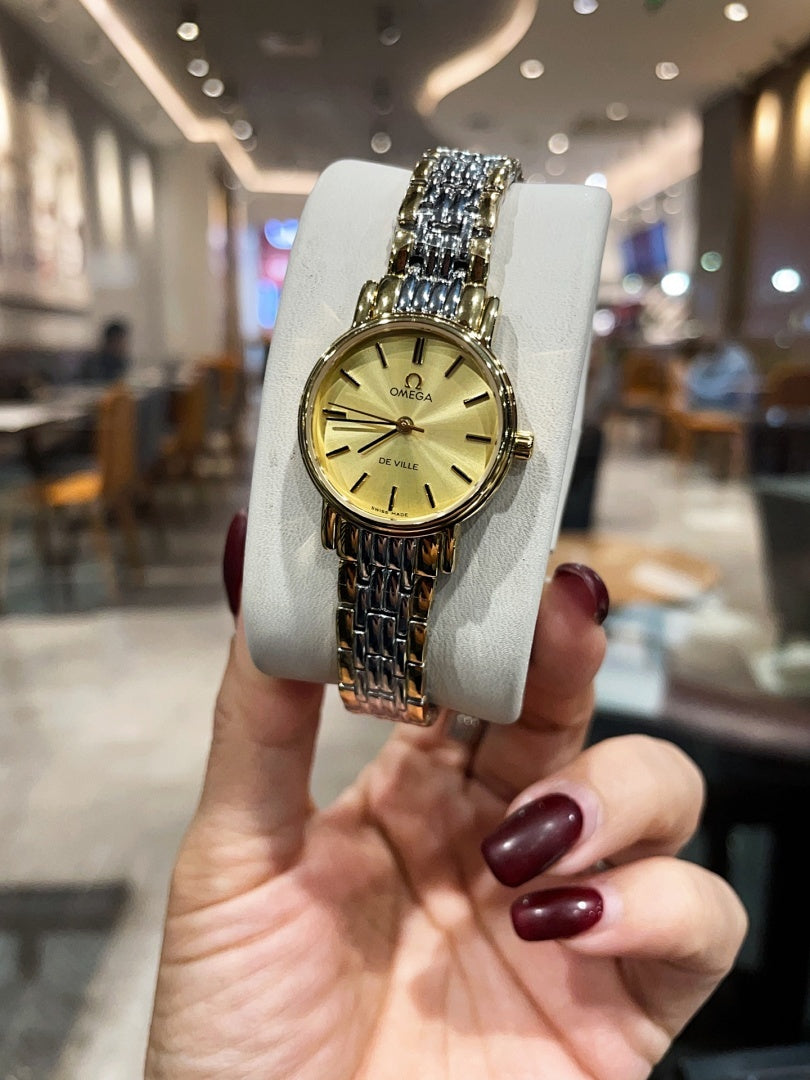 Omega wristwatch with gold dial, gold-tone case, and linked metal bracelet