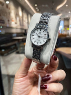 Omega De Ville wristwatch side view, silver bracelet on gray display