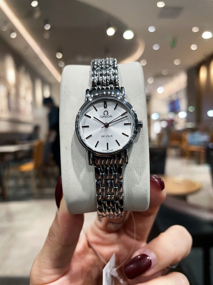 Omega De Ville wristwatch on gray cushion, silver-tone bracelet, front view
