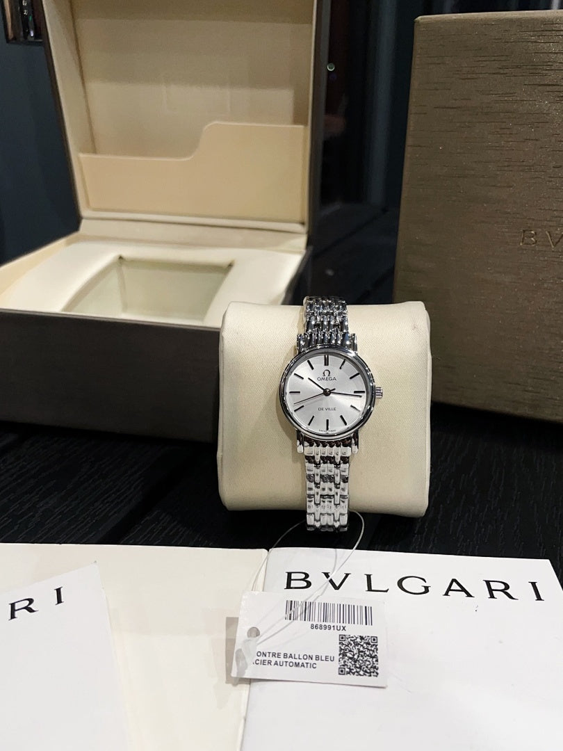 Omega De Ville wristwatch on white display cushion, silver metal bracelet