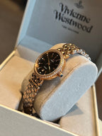 Gold-tone Omega wristwatch with black dial and sparkling gem-set bezel