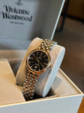 Gold-tone Omega wristwatch with black dial, gem-set bezel, and link bracelet