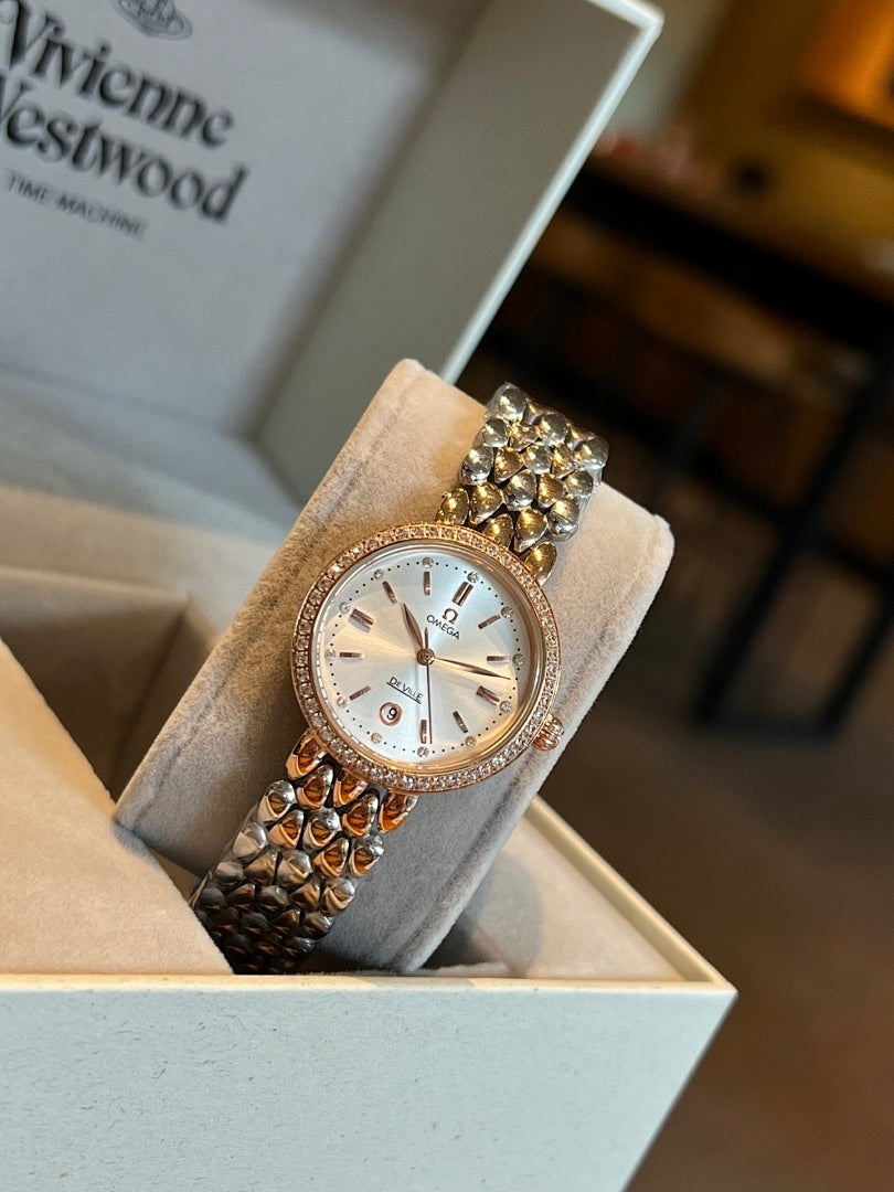 Rose-gold Omega wristwatch with white dial, gem-set bezel, and link bracelet