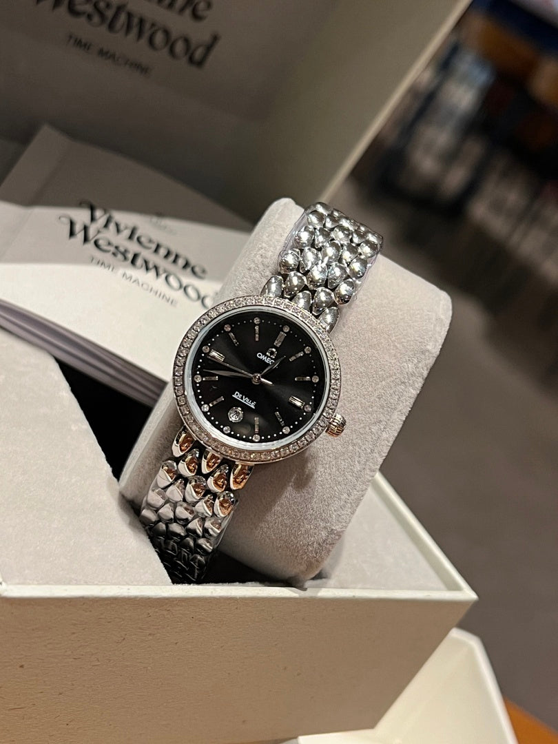 Omega wristwatch with black dial, silver bezel, gem-set crown, textured metal bracelet