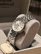 Omega wristwatch with white dial and textured silver bracelet, jeweled bezel detail