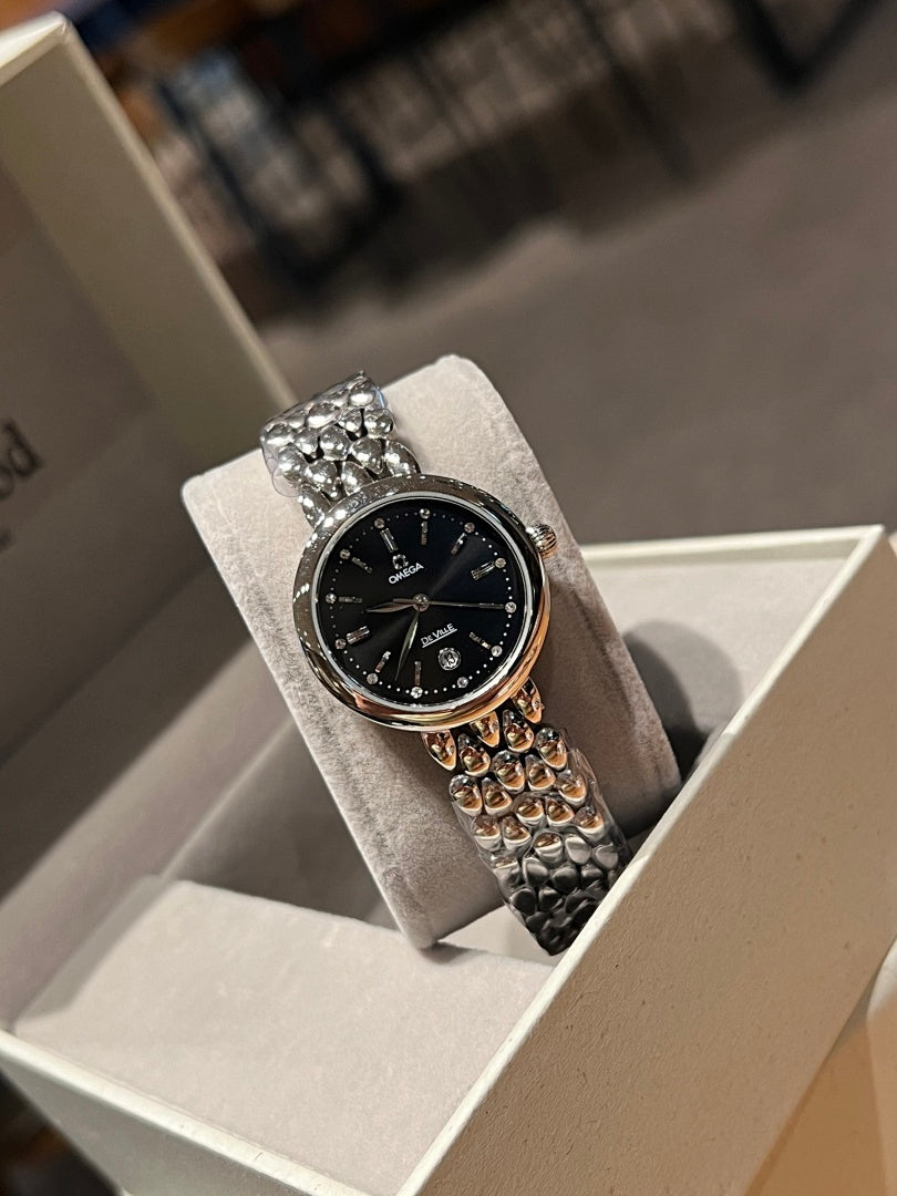 Omega wristwatch with black dial and silver bezel, rhinestone top, textured metal band