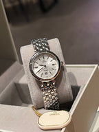 Omega wristwatch with white dial and textured metal bracelet, shown in display tray
