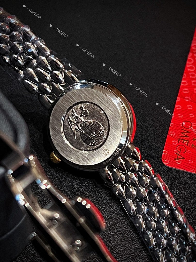 Omega wristwatch caseback with engraved emblem and textured metal link bracelet