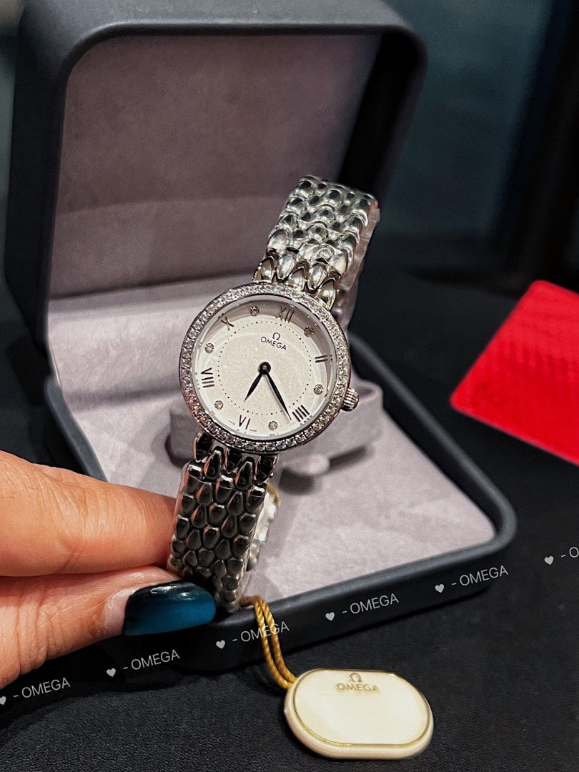 Omega watch with silver link bracelet, white dial, and yellow cord with oval tag