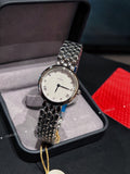 Omega watch with silver link bracelet, white dial, and small round tag on a cord