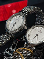 Omega watches with silver link bracelets, white dials, and gem-set bezels
