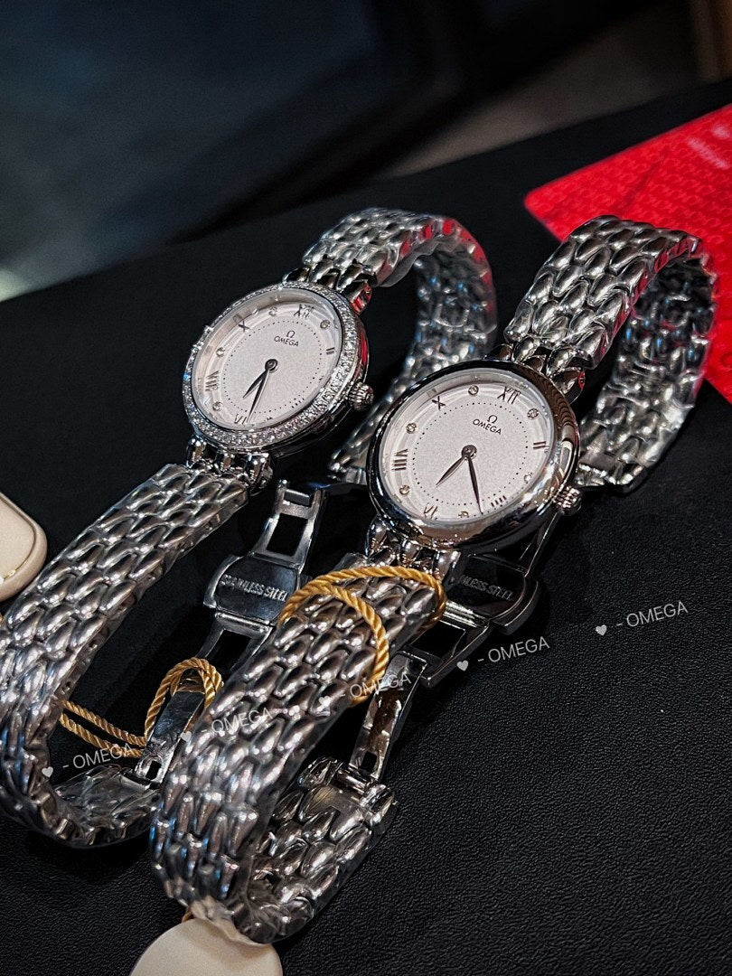 Omega watches with silver link bracelets and white dials, one with diamond bezel