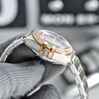 Omega wristwatch case and crystal from an angle, with rose-gold bezel and diamond trim.