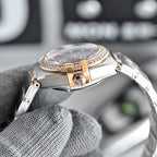 Omega wristwatch back view with rose-gold center details and metal bracelet links.