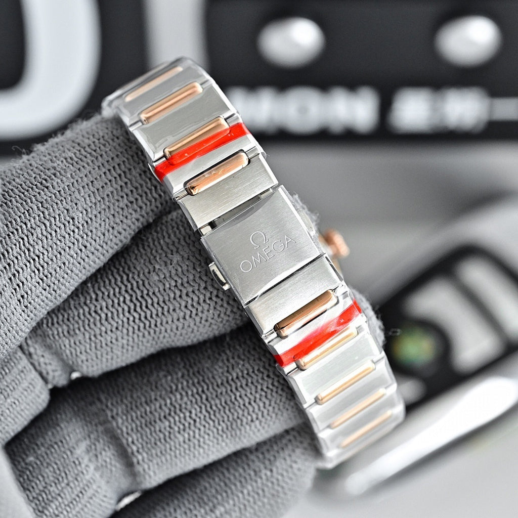 Omega wristwatch side view with metal bracelet and red inlay accents.
