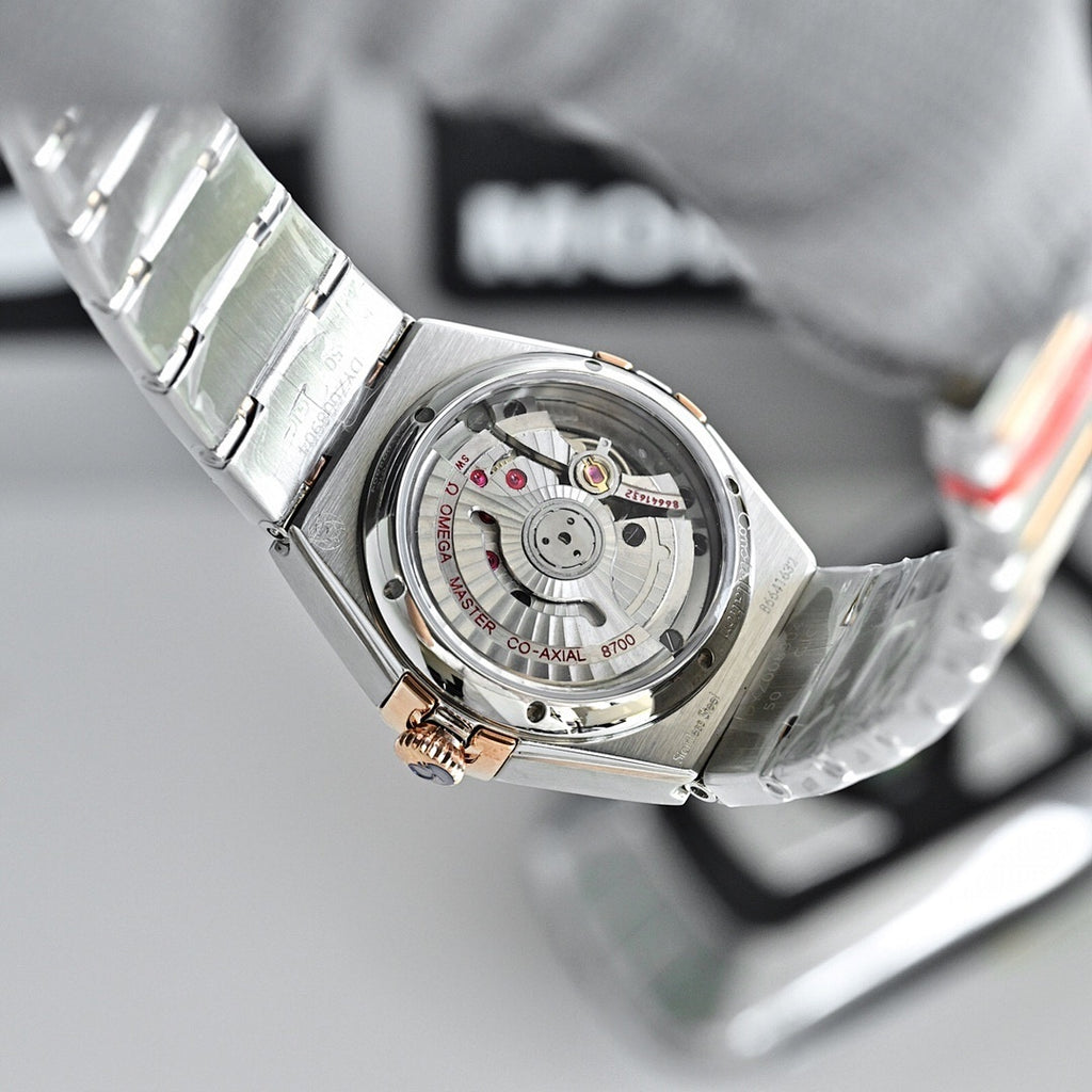 Two-tone wristwatch with visible movement caseback, metal bracelet