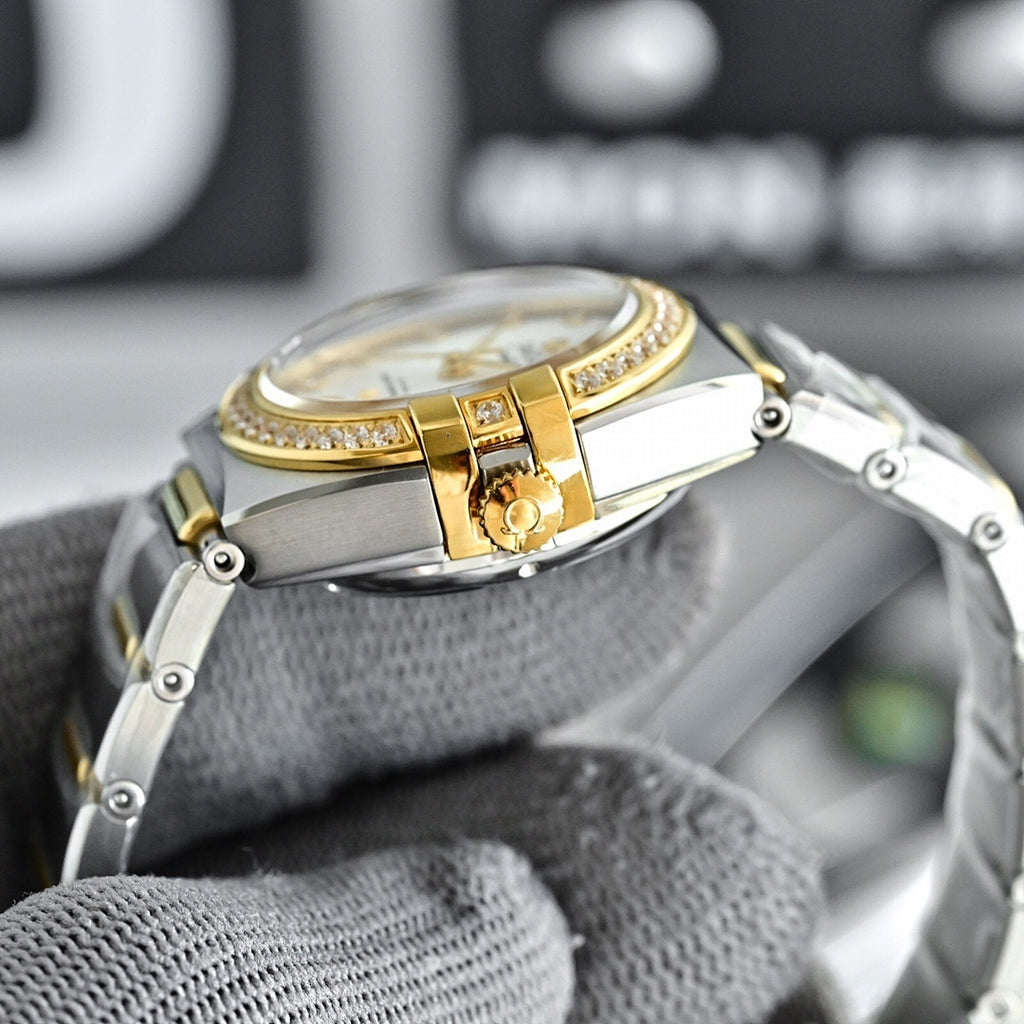 Two-tone watch with gold bezel, gold hands, and steel bracelet clasp close-up