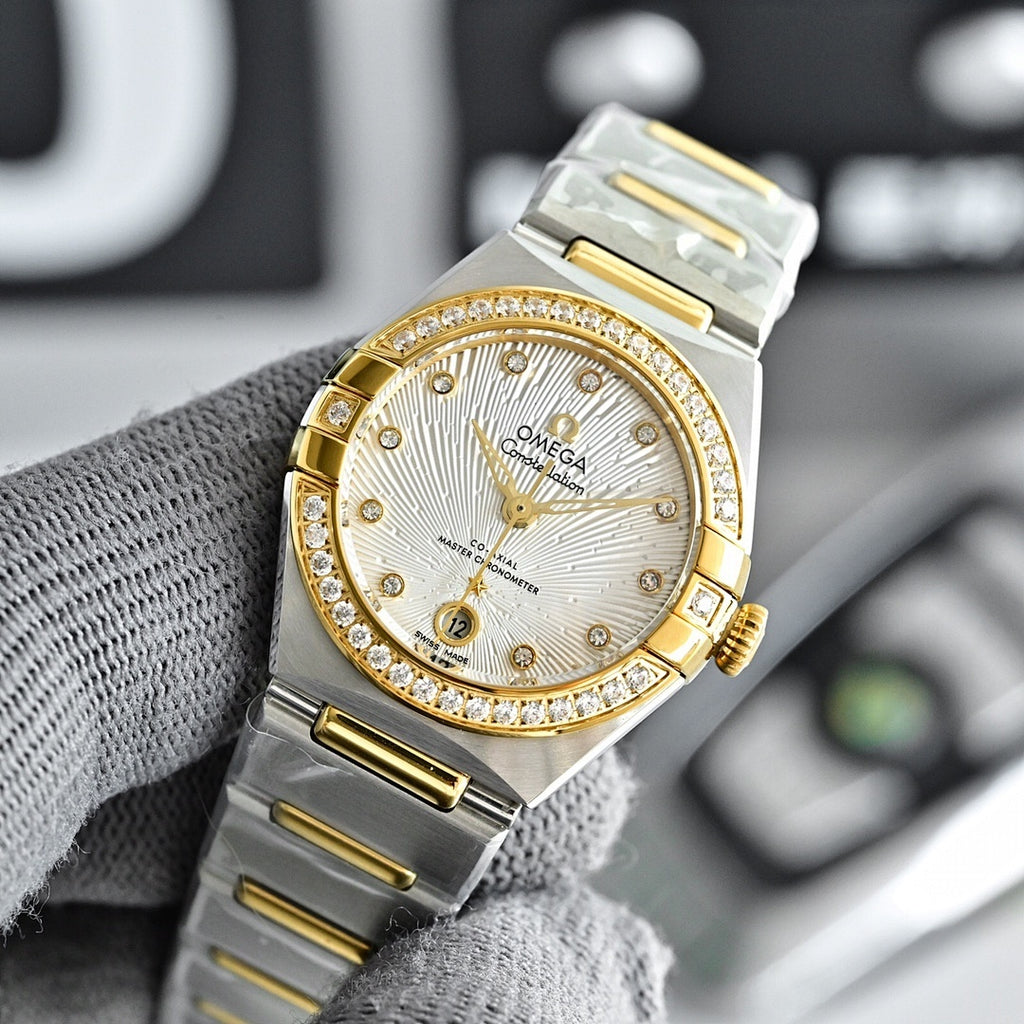 Two-tone watch with white dial, gold bezel with stones, and steel bracelet
