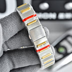 Two-tone watch with silver face, gold side studs, and red accents on steel bracelet