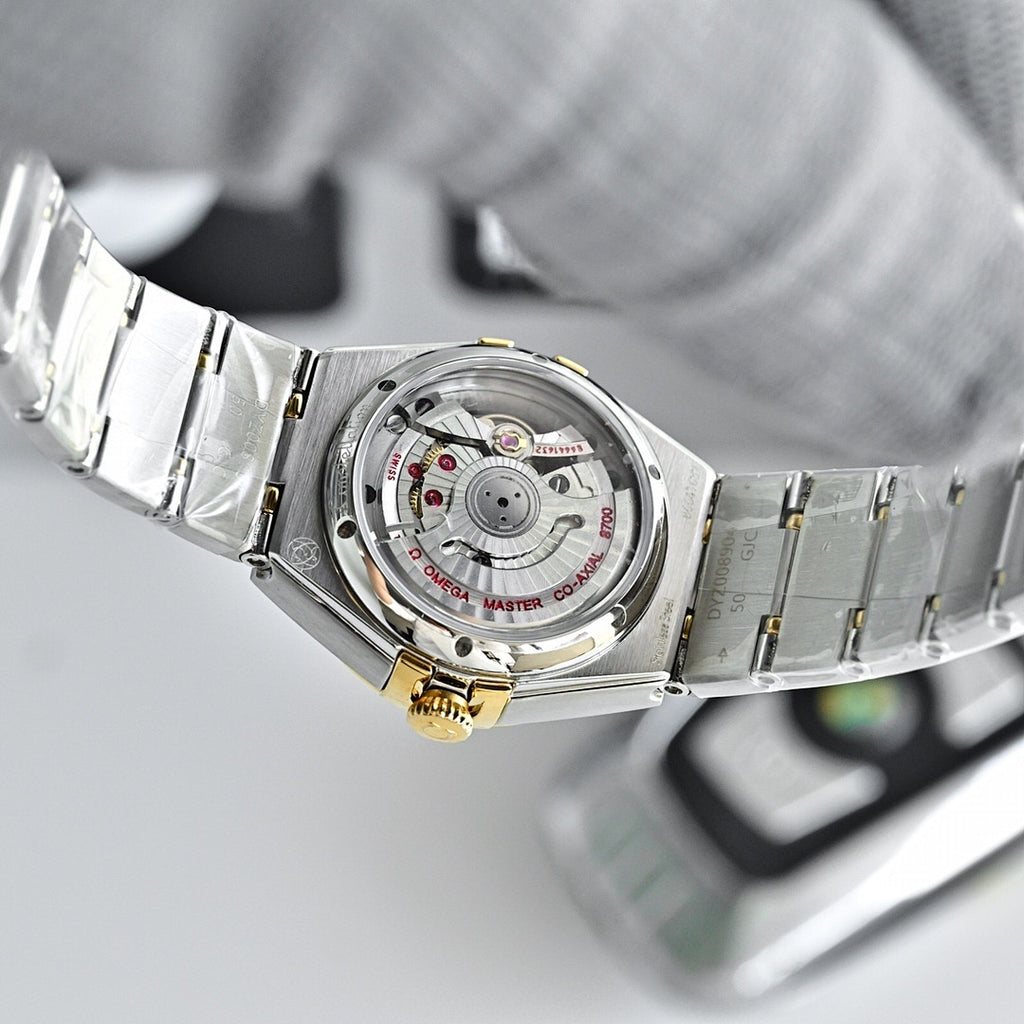 Two-tone watch case back with mechanical dial detail and steel-and-gold bracelet