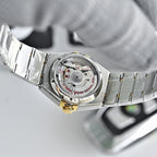 Two-tone watch case back with mechanical dial detail and steel-and-gold bracelet