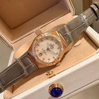 Omega wristwatch with white dial, rose-gold case, gray leather strap, crystal bezel