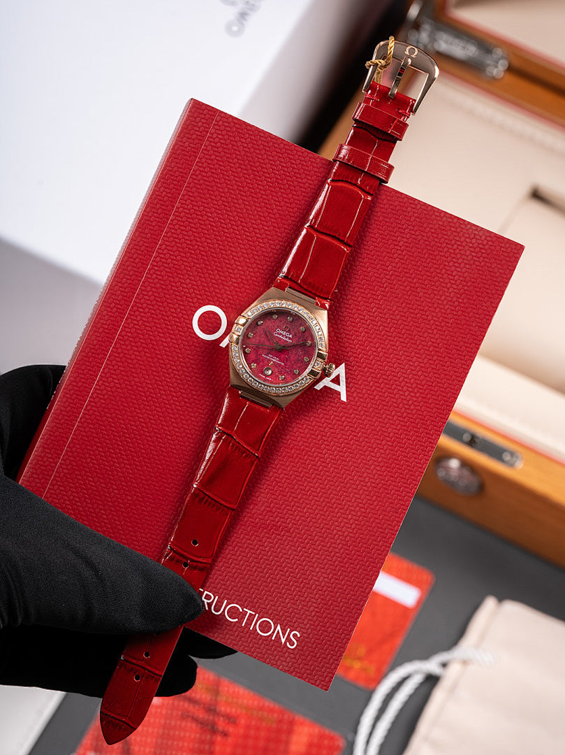 Omega wristwatch, red leather strap with red dial and bezel, held by black glove