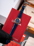 Wristwatch with blue leather strap and round blue dial in red gift box