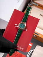 Wristwatch with green leather strap and round teal dial in red gift box
