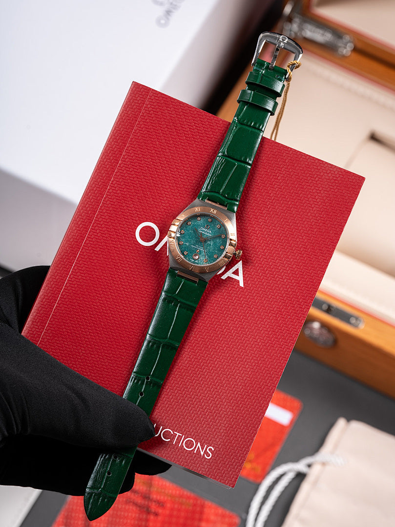 Wristwatch with green leather strap and round teal dial in red gift box
